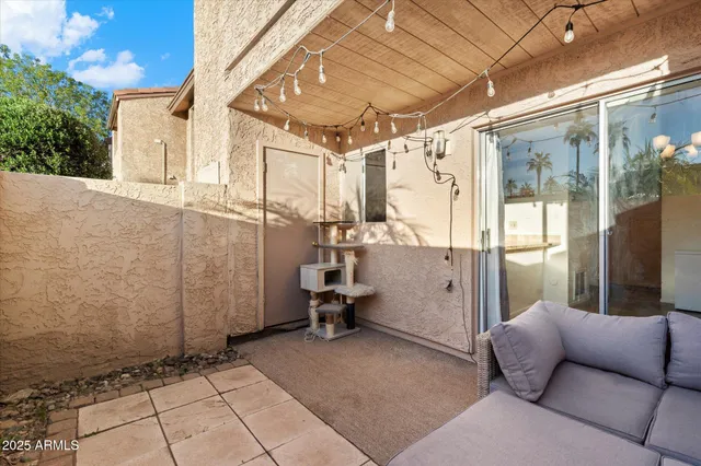a view of a house with a table and chairs under an umbrella