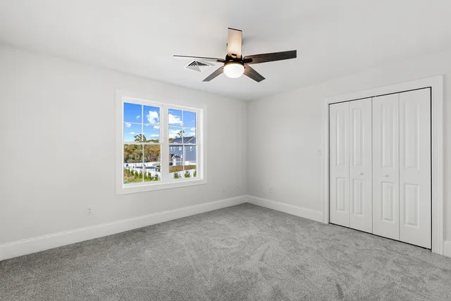a view of a livingroom with a ceiling fan and window