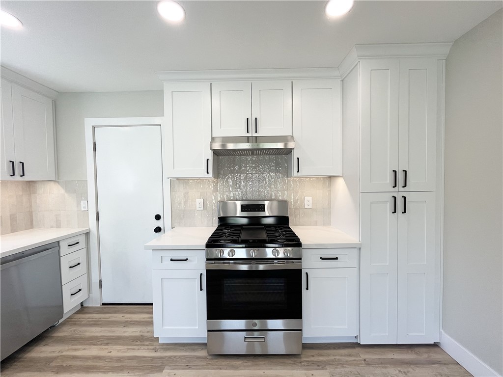 13004 Chestnut Avenue Rancho Cucamonga, CA 91739 - Photo 7 of 28 a kitchen with a stove and white cabinets