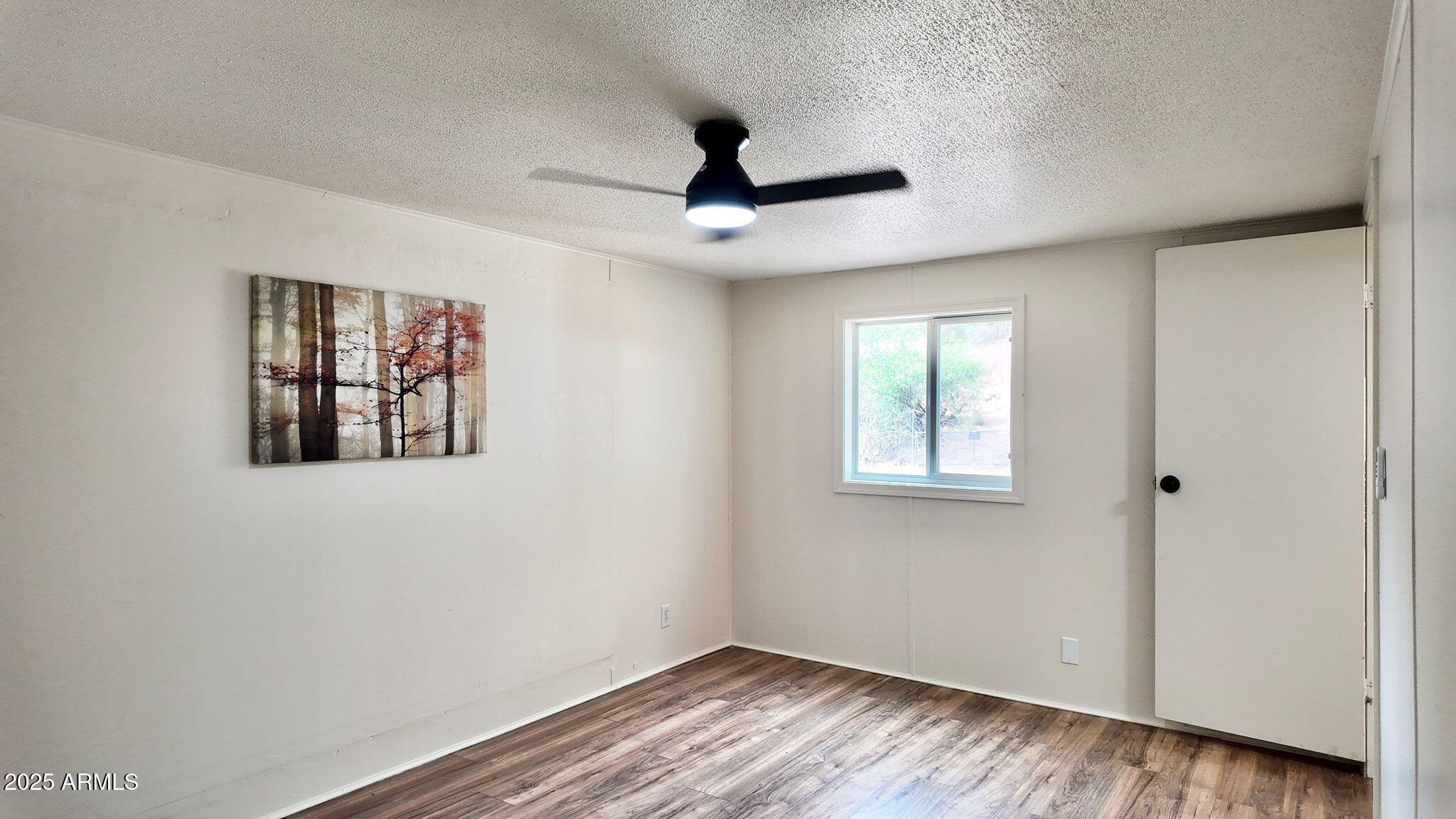 647 South Moonlight Drive Payson, AZ 85541 - Photo 27 of 50 a view of an empty room with a window and wooden floor