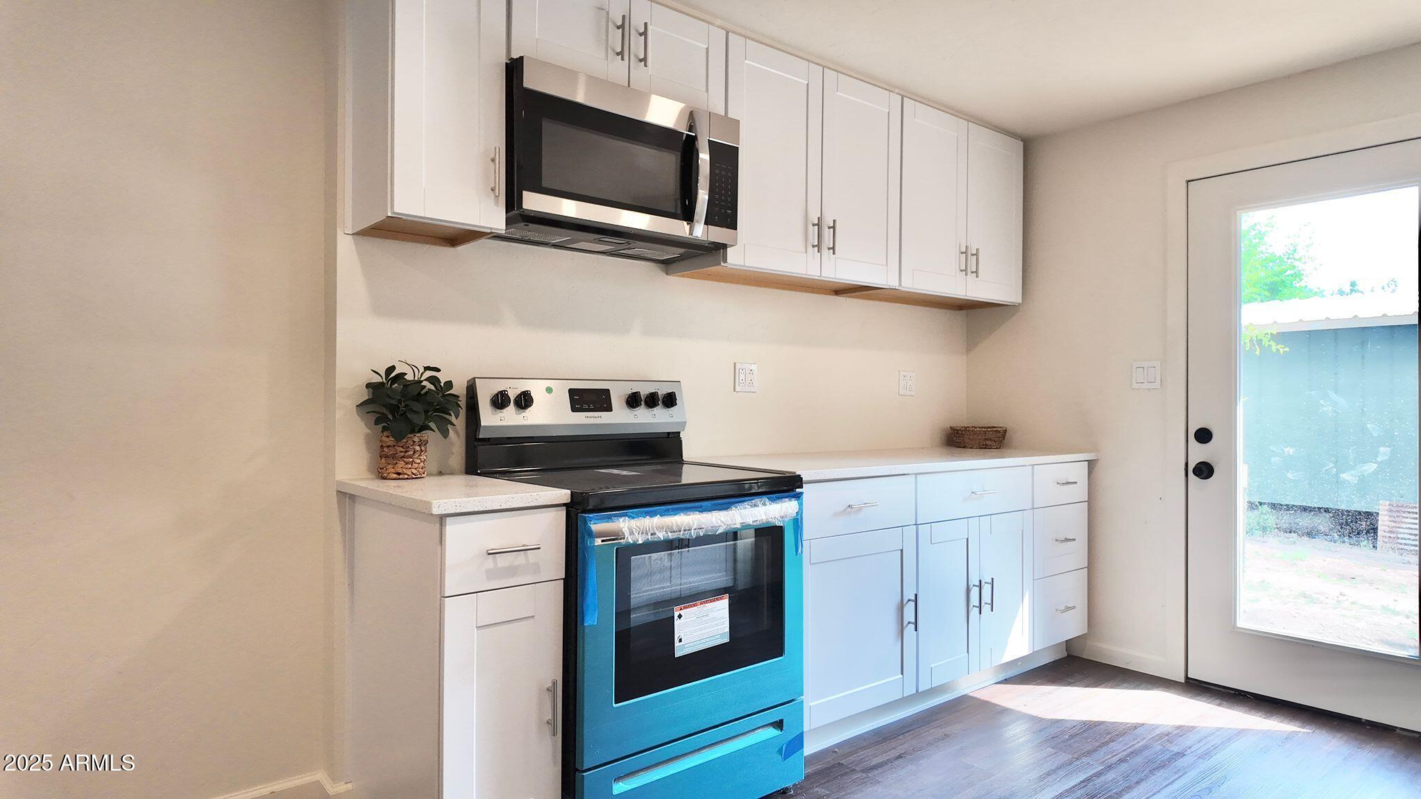 647 South Moonlight Drive Payson, AZ 85541 - Photo 7 of 50 a kitchen with white cabinets stainless steel appliances and wooden floor