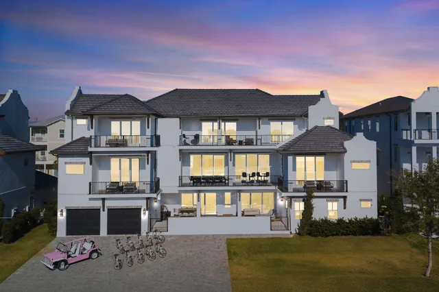 a living room with furniture a large window and wooden floor