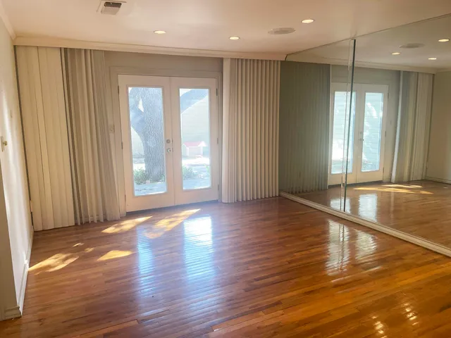 a view of an empty room with wooden floor
