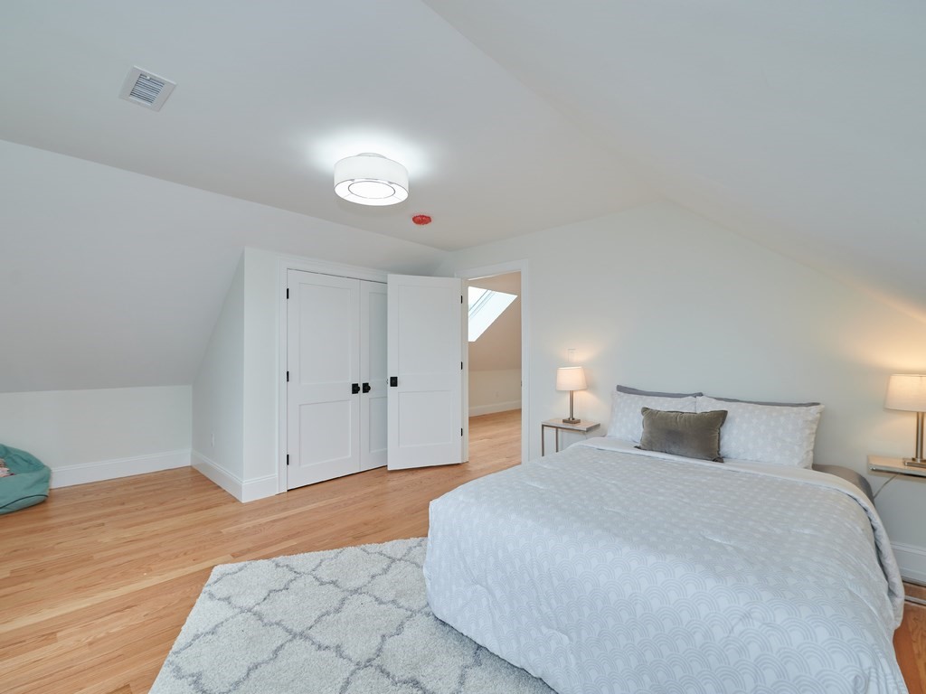 26 Old Colony Road Arlington, MA 02474 - Photo 22 of 32 a bedroom with a bed and a lamp on dresser