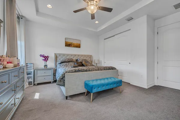 a spacious bedroom with a bed and a chandelier