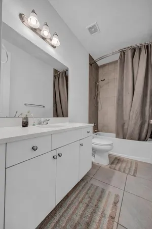 a bathroom with a double vanity sink a toilet and a mirror