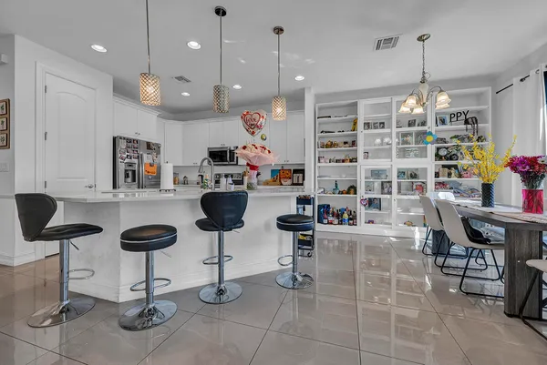 a room with lots of white furniture and a chandelier