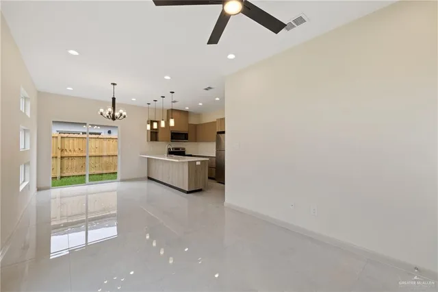 a large kitchen with a sink stainless steel appliances and cabinets