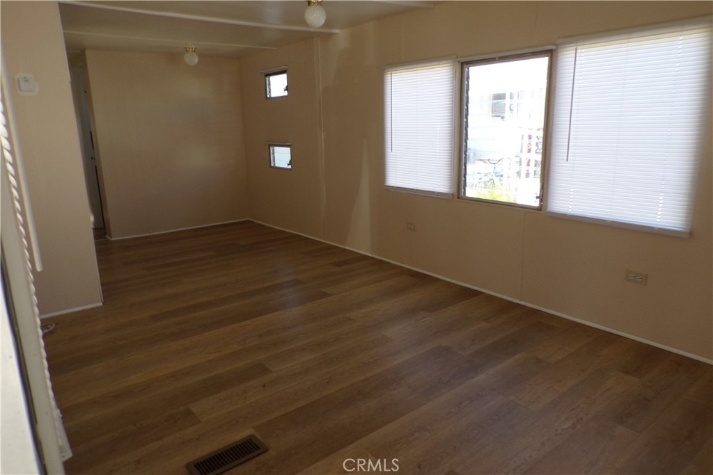 12710 3rd Street, Unit 36 Yucaipa, CA 92399 - Photo 3 of 10 an empty room with wooden floor and windows