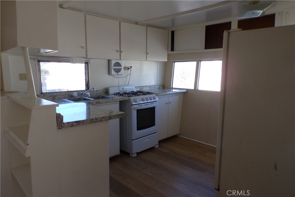 12710 3rd Street, Unit 36 Yucaipa, CA 92399 - Photo 6 of 10 a kitchen with stainless steel appliances a stove a sink and a refrigerator
