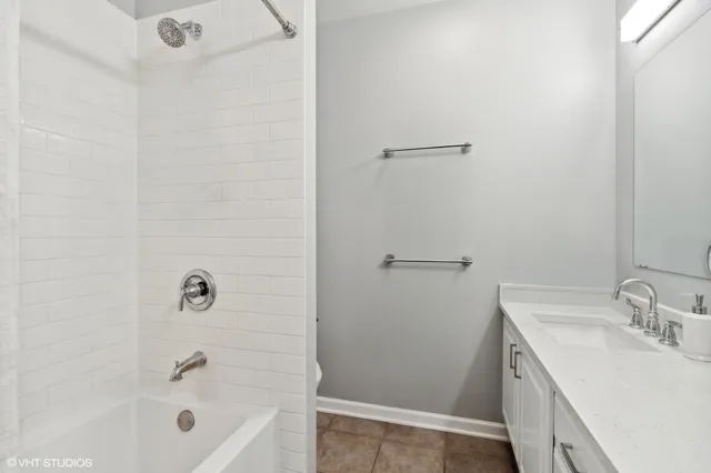 a bathroom with a tub sink vanity and mirror