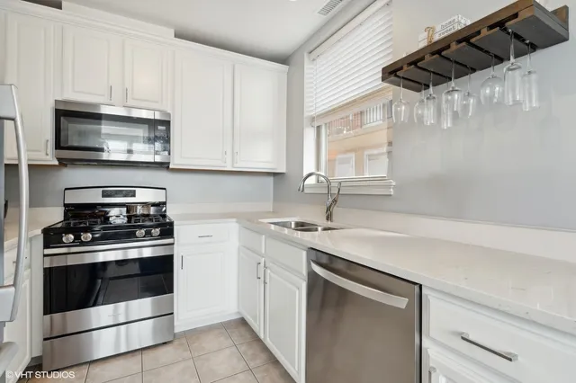 a kitchen with stainless steel appliances granite countertop a sink a stove and a microwave