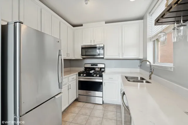 a kitchen with stainless steel appliances a refrigerator sink and microwave
