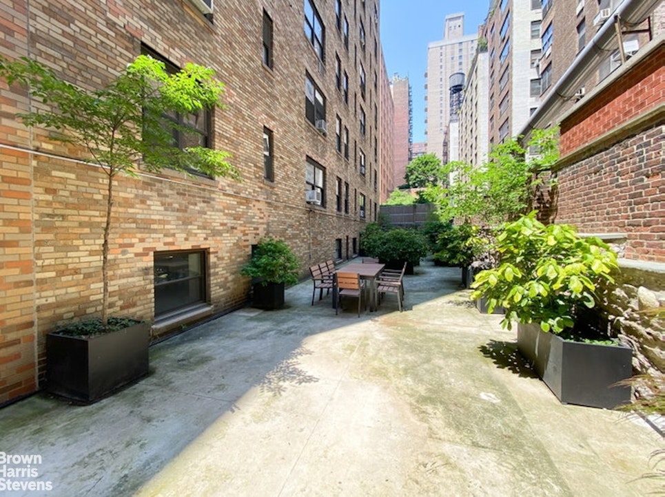245 East 72nd Street, Unit 11A Manhattan, NY 10021 - Photo 15 of 16 a view of a patio with plants and a fireplace