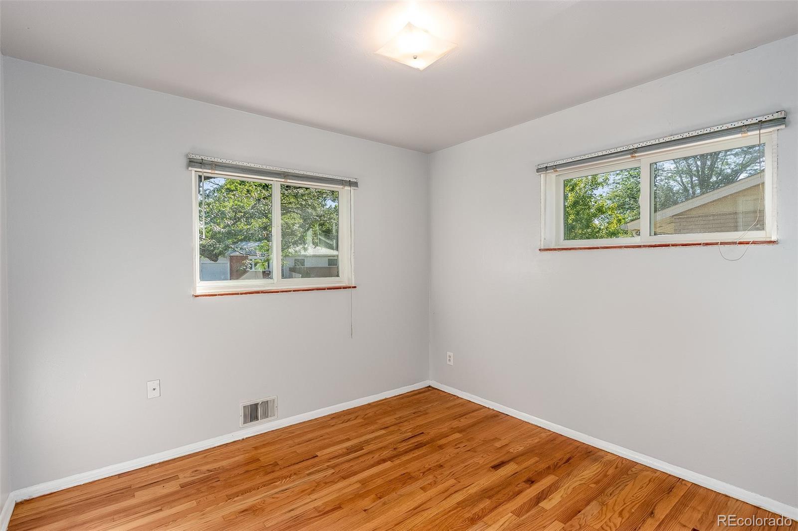 3217 South Stuart Street Denver, CO 80236 - Photo 14 of 30 a view of an empty room with wooden floor and a window