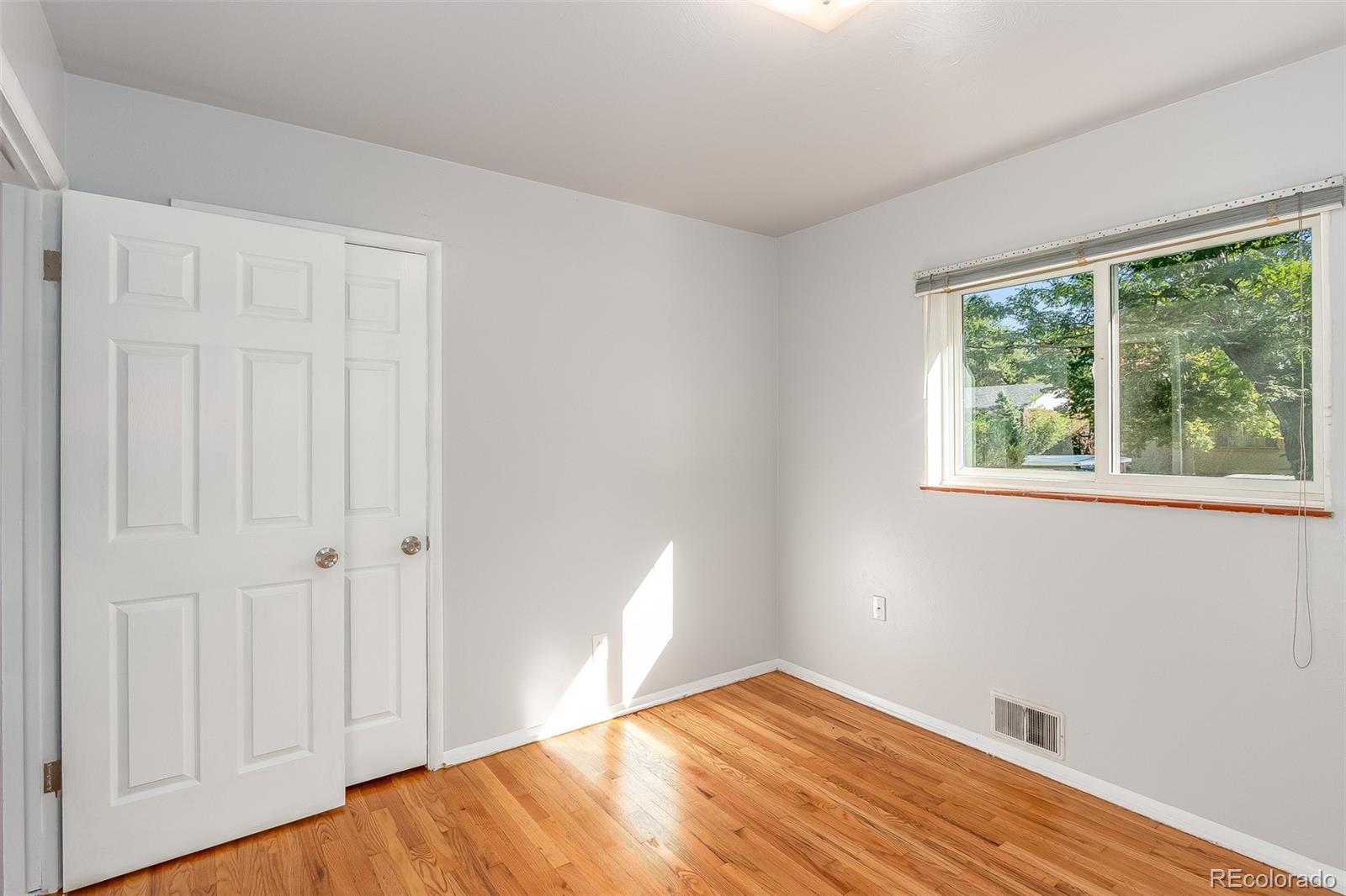 3217 South Stuart Street Denver, CO 80236 - Photo 17 of 30 a view of empty room with wooden floor and fan