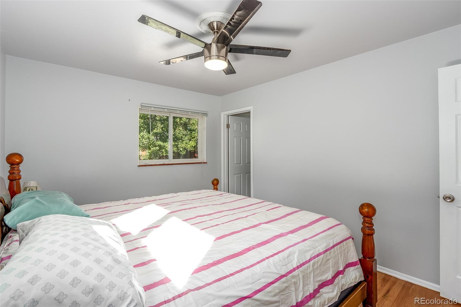 3217 South Stuart Street Denver, CO 80236 - Photo 19 of 30 a bedroom with a bed and a chandelier