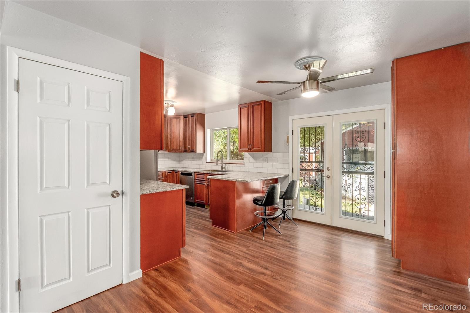 3217 South Stuart Street Denver, CO 80236 - Photo 6 of 30 a view of living room kitchen with hardwood floor and a ceiling fan