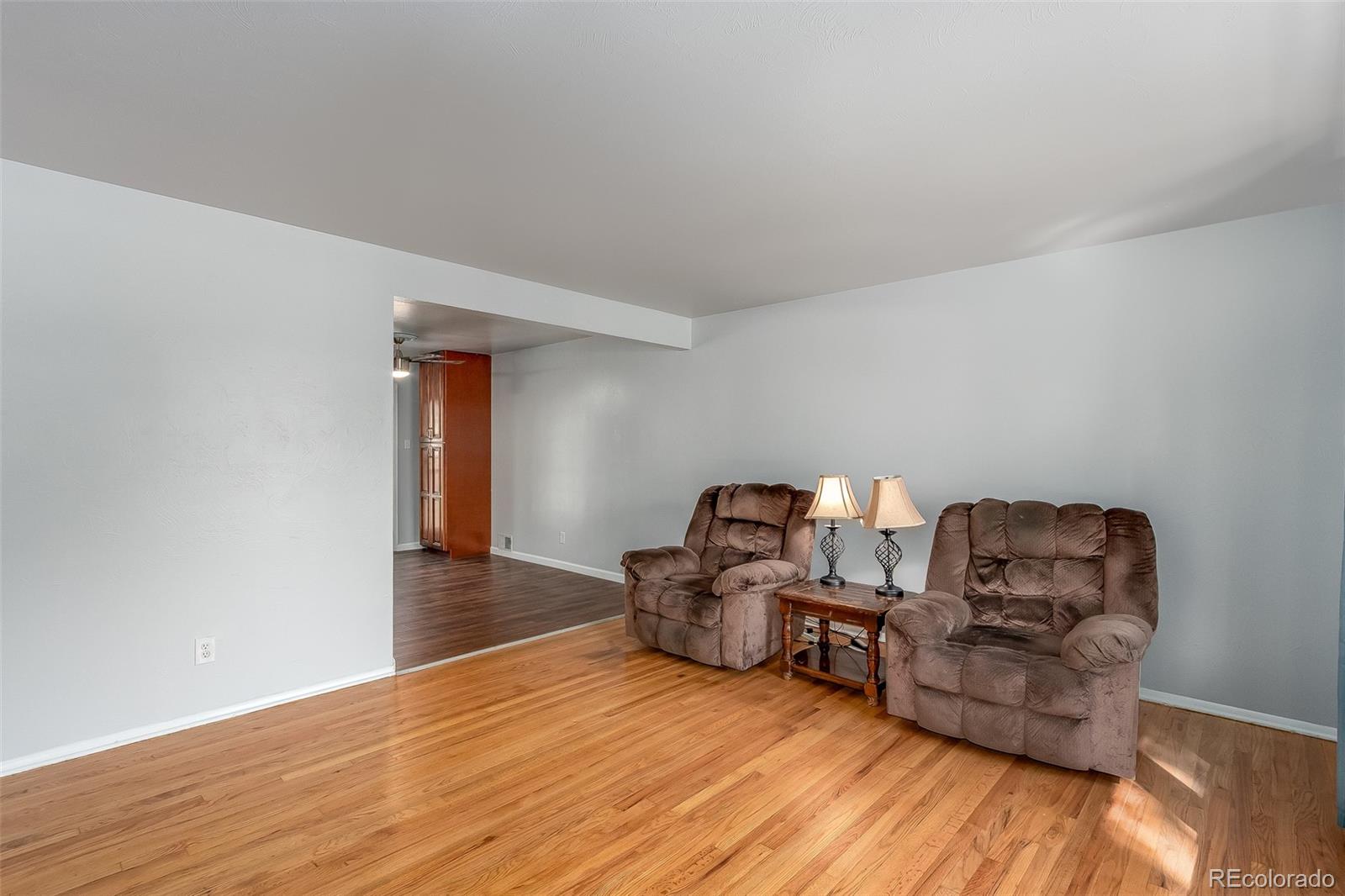 3217 South Stuart Street Denver, CO 80236 - Photo 9 of 30 a living room with furniture and a wooden floor