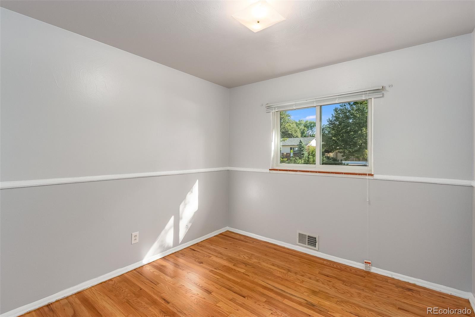 3217 South Stuart Street Denver, CO 80236 - Photo 10 of 30 a view of empty room with wooden floor and fan