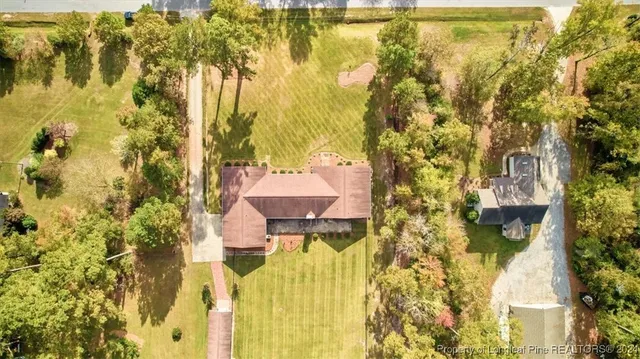 a aerial view of a house with swimming pool and large trees