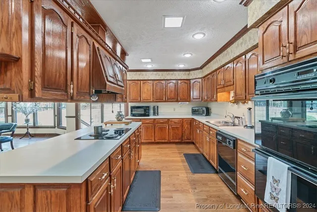 a kitchen with stainless steel appliances granite countertop sink stove top oven and cabinets