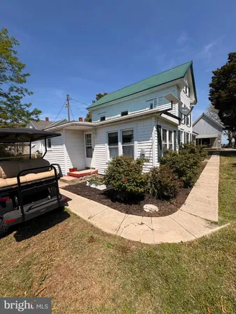 a view of a white house with a yard