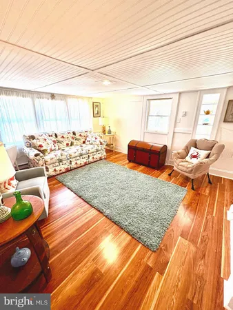 a kitchen with stainless steel appliances white cabinets a sink and a wooden floor