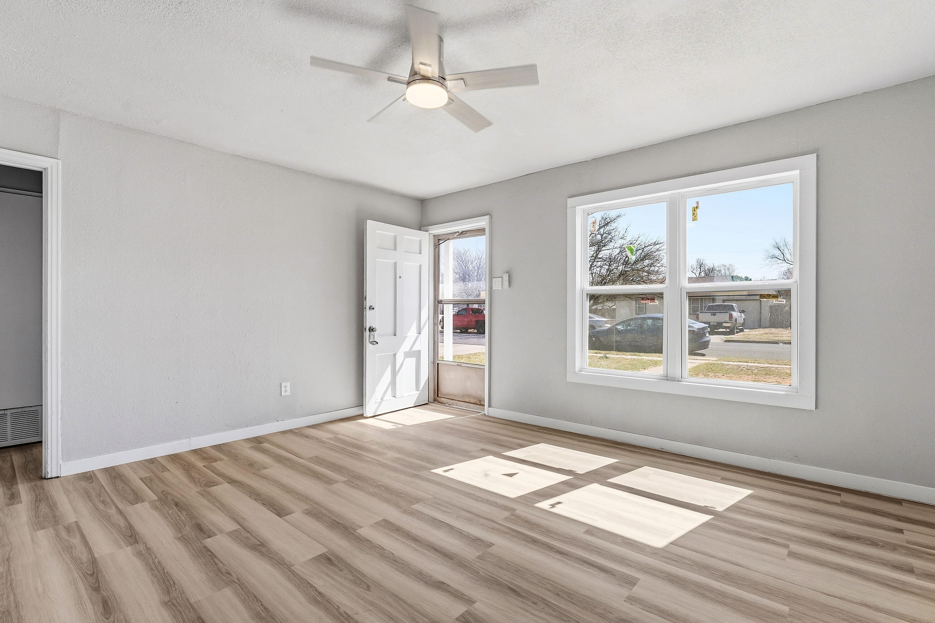 2814 40th Street Lubbock, TX 79413 - Photo 4 of 11 a view of an empty room with a window and wooden floor