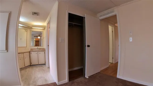 a view of a hallway with closet and wooden floor