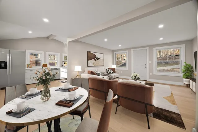 a living room with furniture kitchen view and a large window