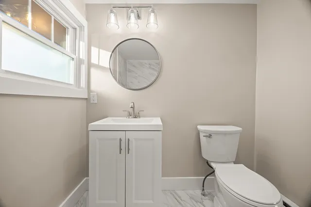 a bathroom with a toilet a sink and mirror