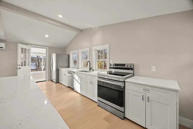 a kitchen with white cabinets and stainless steel appliances