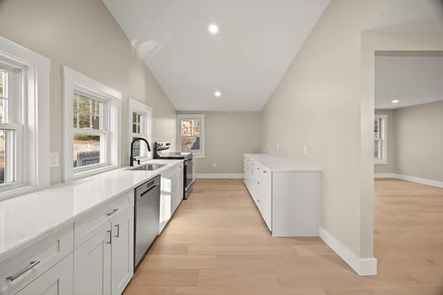 a large white kitchen with white cabinets and a sink