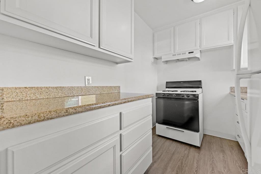 4530-32 4th Street La Mesa, CA 91941 - Photo 19 of 50 a kitchen with granite countertop white cabinets and white appliances