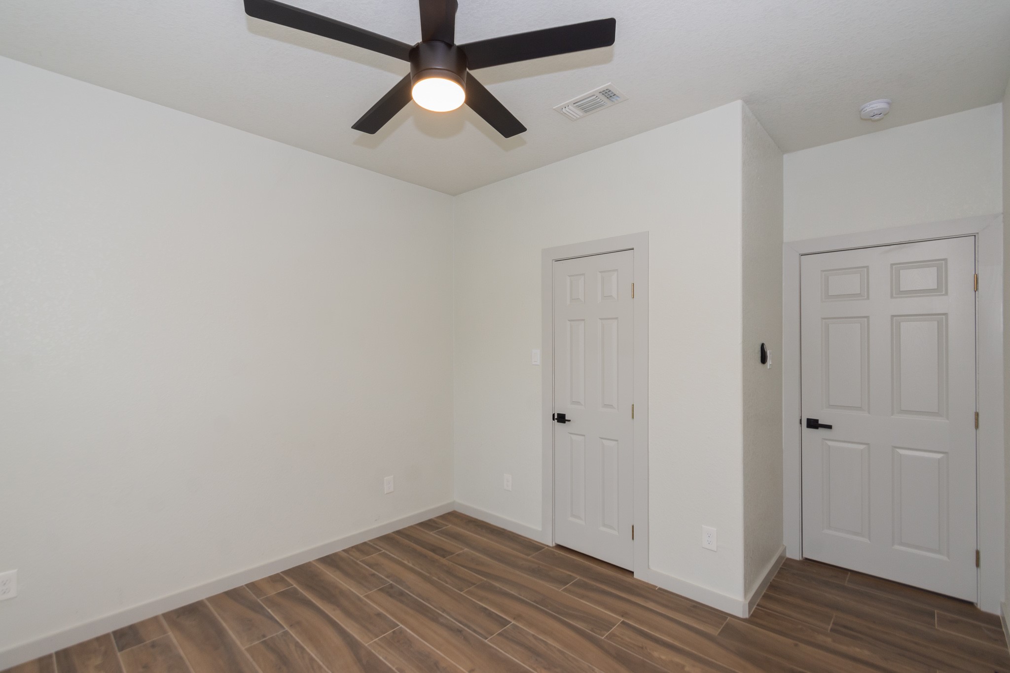 2190 Riverside Drive West Columbia, TX 77486 - Photo 32 of 39 an empty room with wooden floor and ceiling fan