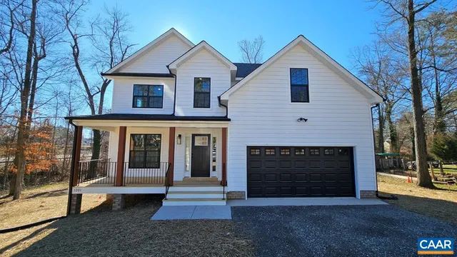 a view of a house with a yard and large tree