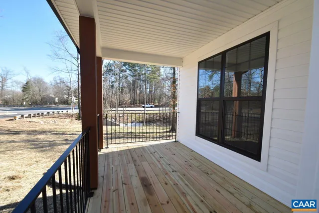 a view of a room with wooden floor and a floor to ceiling window