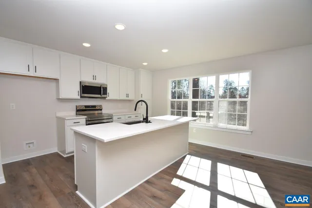 a kitchen with a sink a stove a microwave and cabinets