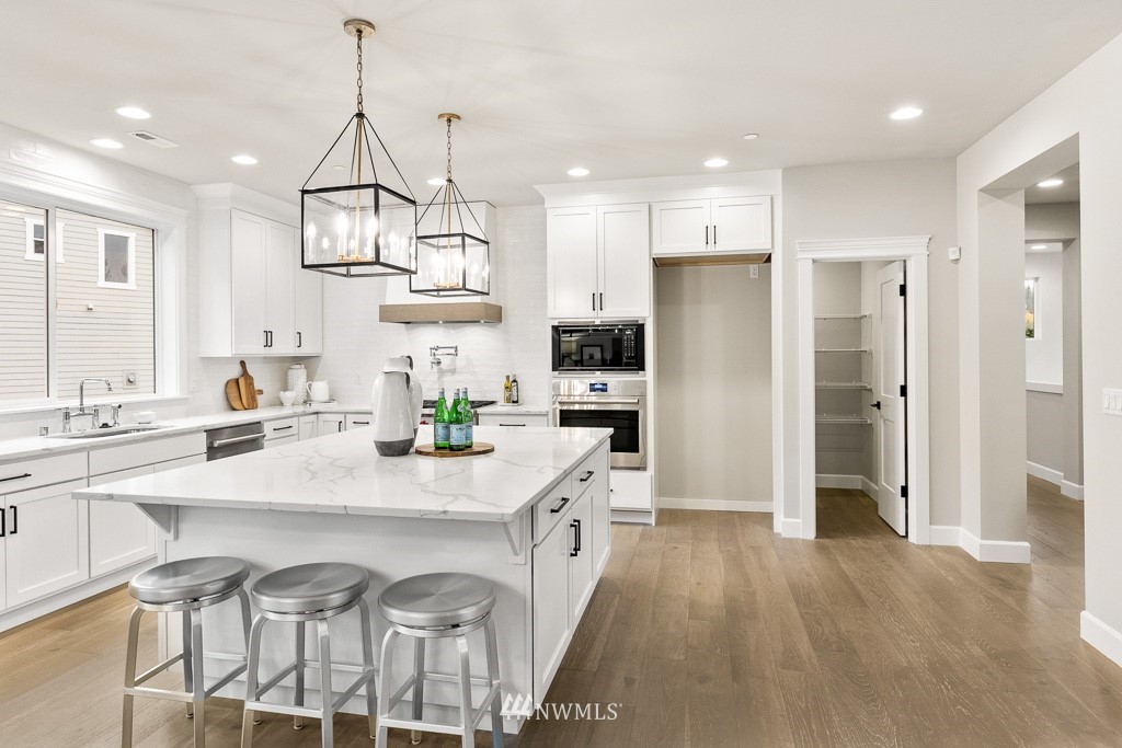22915 31st Avenue Southeast Bothell, WA 98021 - Photo 18 of 40 a kitchen with stainless steel appliances granite countertop a refrigerator a sink dishwasher a stove and white cabinets with wooden floor