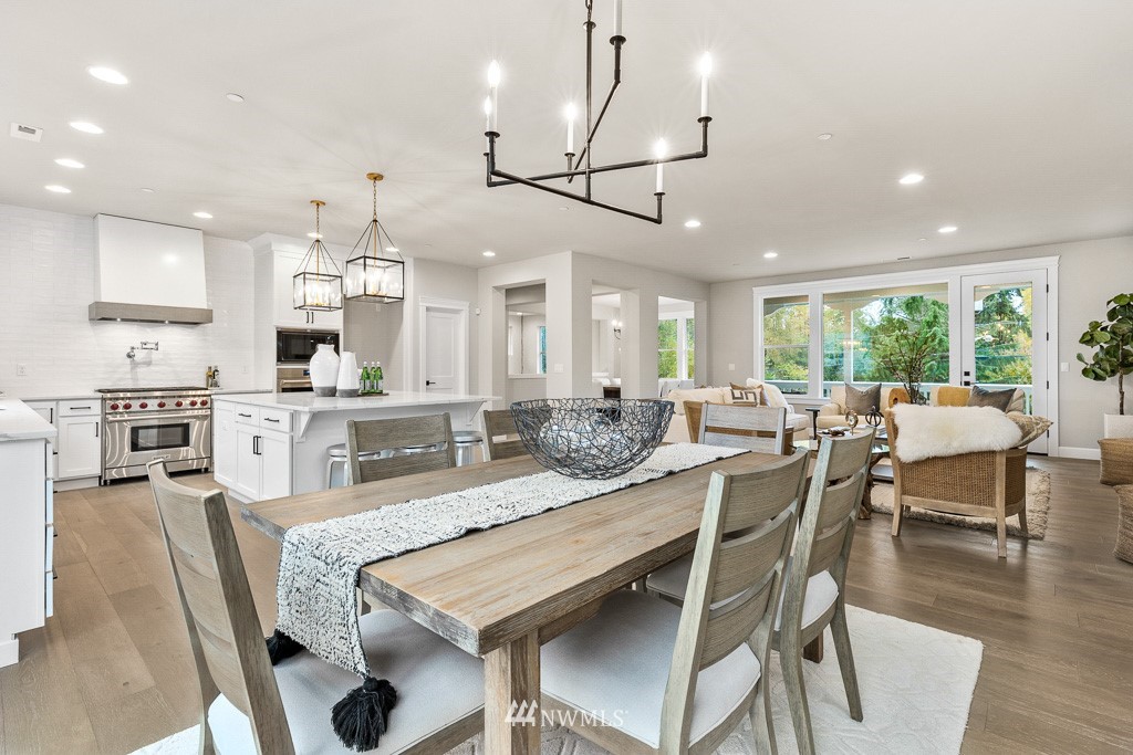22915 31st Avenue Southeast Bothell, WA 98021 - Photo 23 of 40 a dining room with stainless steel appliances kitchen island granite countertop a dining table chairs and wooden floor