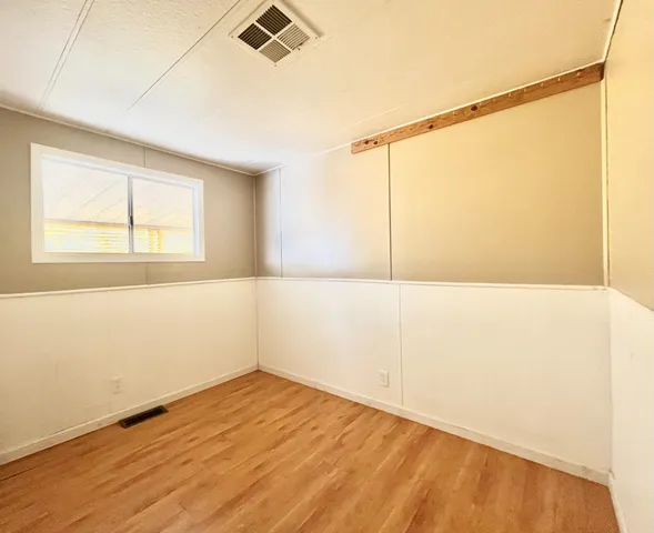 a view of a room with wooden floor and a window