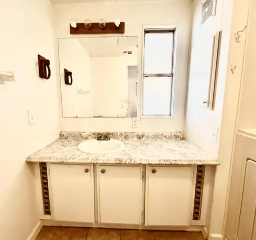 a bathroom with a granite countertop sink and a mirror