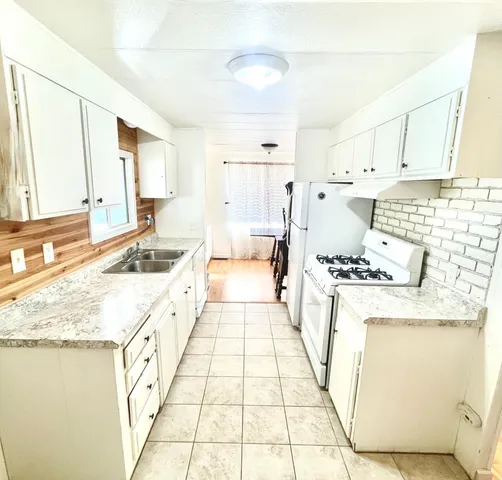 a kitchen with stainless steel appliances granite countertop a sink stove and white cabinets