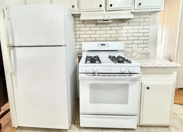 a white refrigerator freezer sitting inside of a kitchen