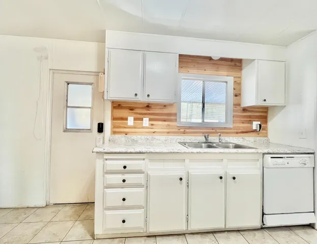 a kitchen with granite countertop white cabinets and white appliances