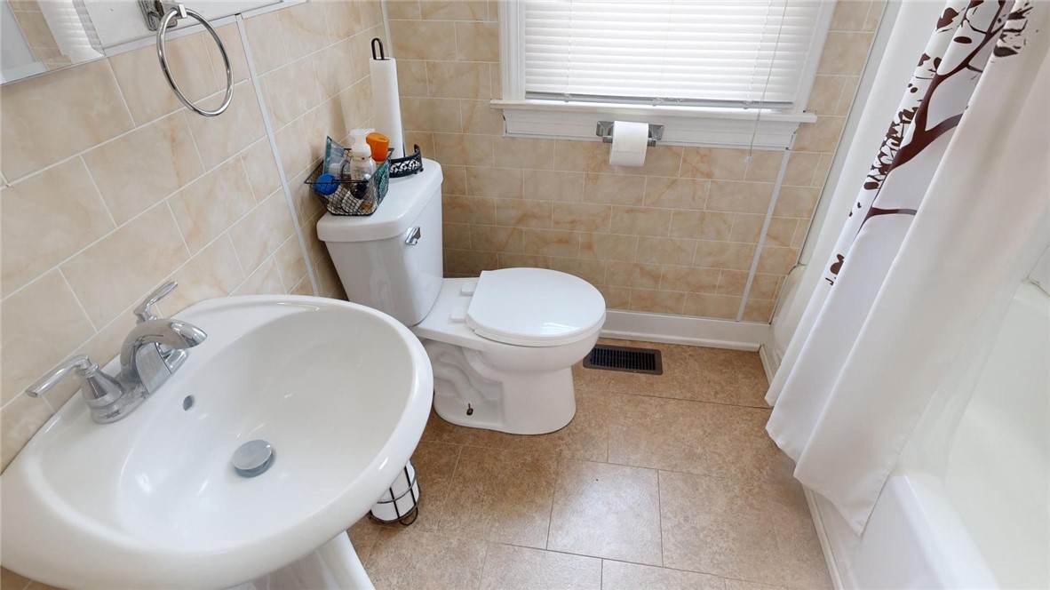 956 North University Avenue Decatur, IL 62522 - Photo 13 of 24 a bathroom with a sink a toilet and a mirror