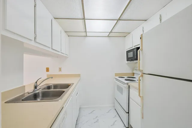 a kitchen with stainless steel appliances granite countertop a sink a refrigerator and a stove