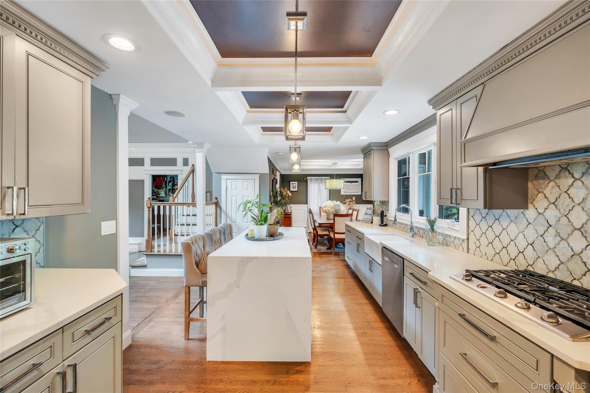 19 Joan Road Bay Shore, NY 11706 - Photo 11 of 50 Gourmet kitchen with a waterfall edge island, recessed lighting, coffered ceiling detail, gas range, and geometric tile backsplash
