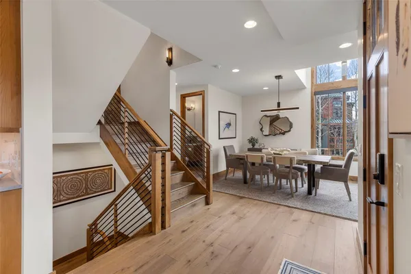 a view of a dining room and livingroom with furniture wooden floor a rug and a chandelier